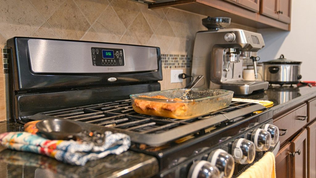 "a stainless gas range with cast grates in a kitchen of dark cabinets" — freestanding, gas, dark room: the deepest code branch this make has and the palette this site is in